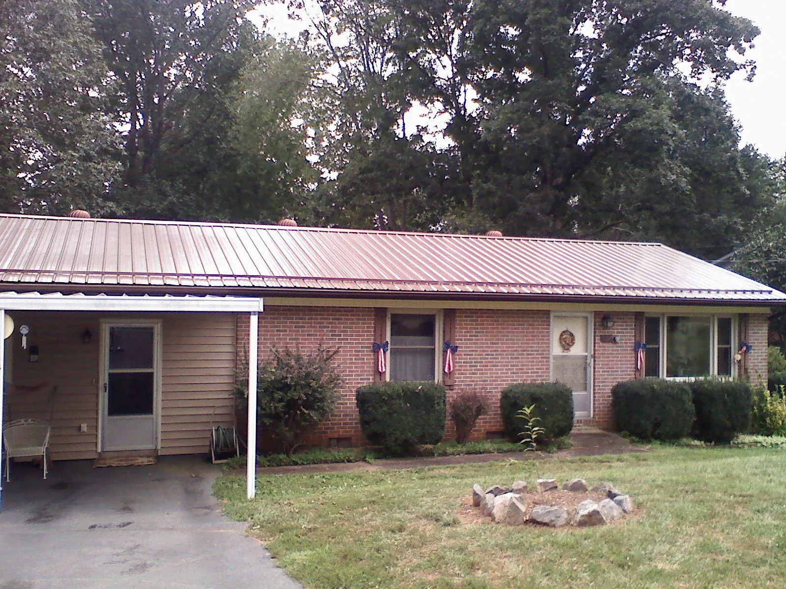 Bronze metal roof and carport on a brick ranch home — Roof Repair work by our crew in Woodland